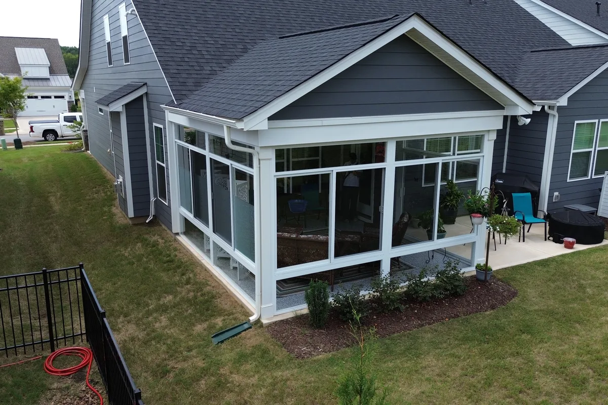White aluminum frame and glass panel system on the Mantle Ridge porch enclosure in Indian Trail NC showing the full exterior elevation