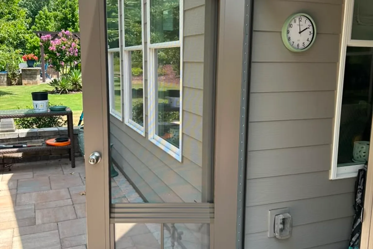 Custom 36x80 out-swing door with integrated vinyl-film window installed on Belmont NC enclosure