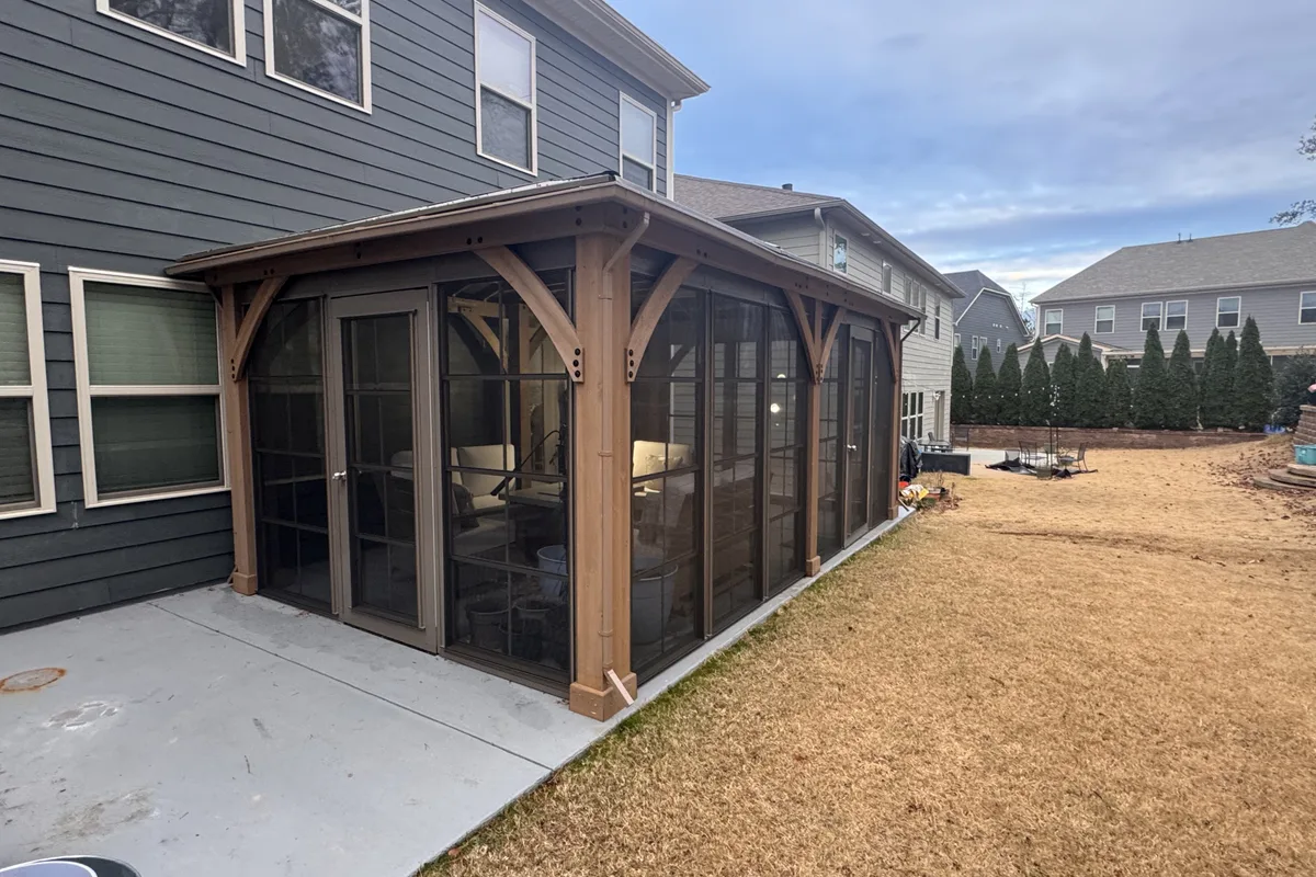 Wide exterior shot of finished 3-season vinyl film enclosure on prefab hardtop pergola in Clems Branch Mecklenburg County NC showing full symmetrical panel layout