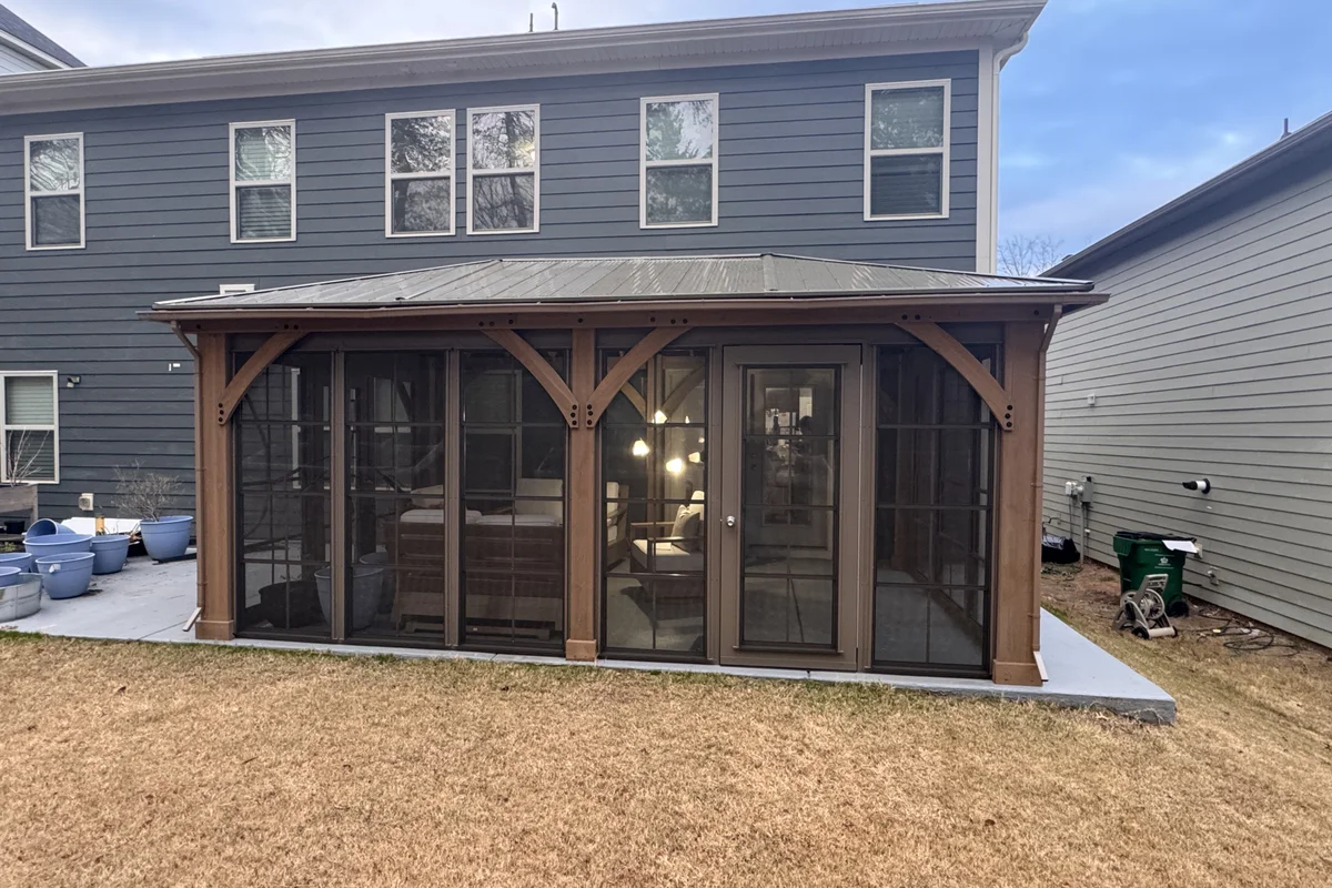 Completed 3-season vinyl film enclosure on prefab hardtop pergola in Clems Branch Charlotte NC showing Craft-Bilt stacking windows and door after installation